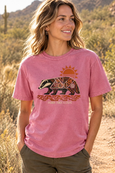Pink badger tee on a sunny trail