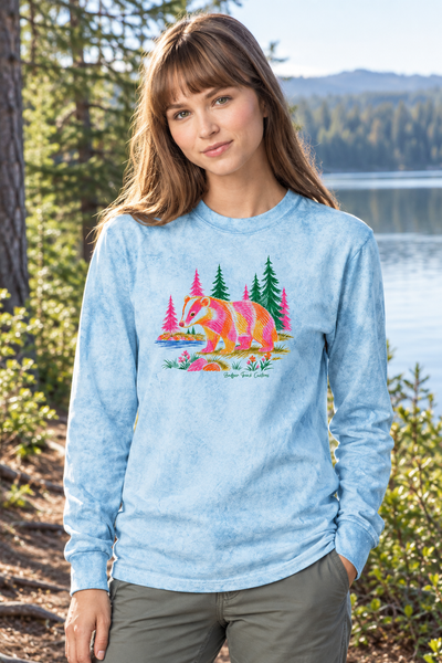 Woman wearing the colorful badger long-sleeve shirt by a lake